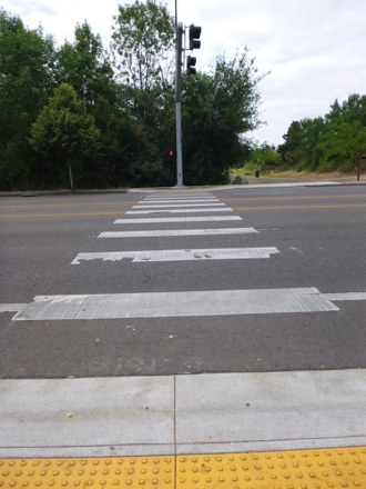 Crosswalk with tactile warnings crosses Hall Blvd connecting to Greenway Park